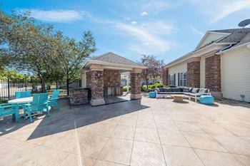 A sunny day at a patio with a table and chairs.